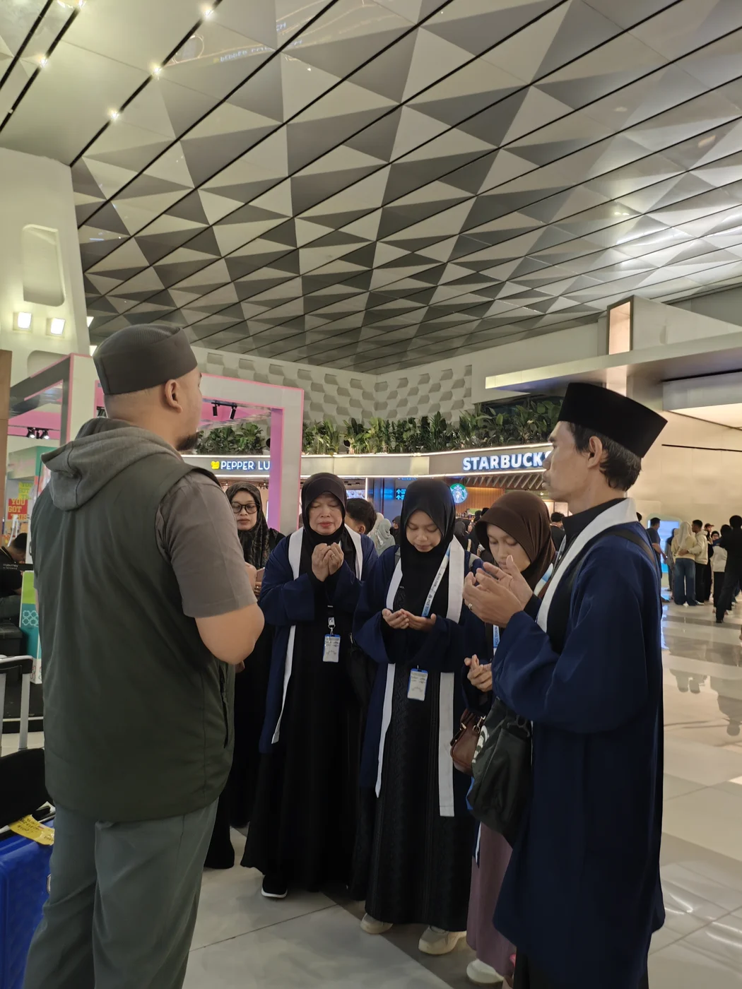 Dokumentasi doa bersama rombongan jamaah dan pembimbing ibadah PGS Tour di bandara sebelum keberangkatan